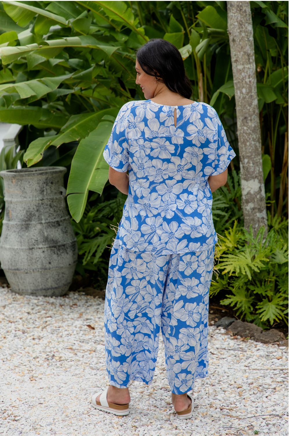 Palazzo pants in blue and white Hawaiian being worn by lady in beach resort