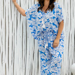 Woman wearing a blue floral relaxed fit pants and matching kaftan top on summer day
