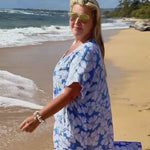 women wearing blue and white floral long kaftan dress walking along beach