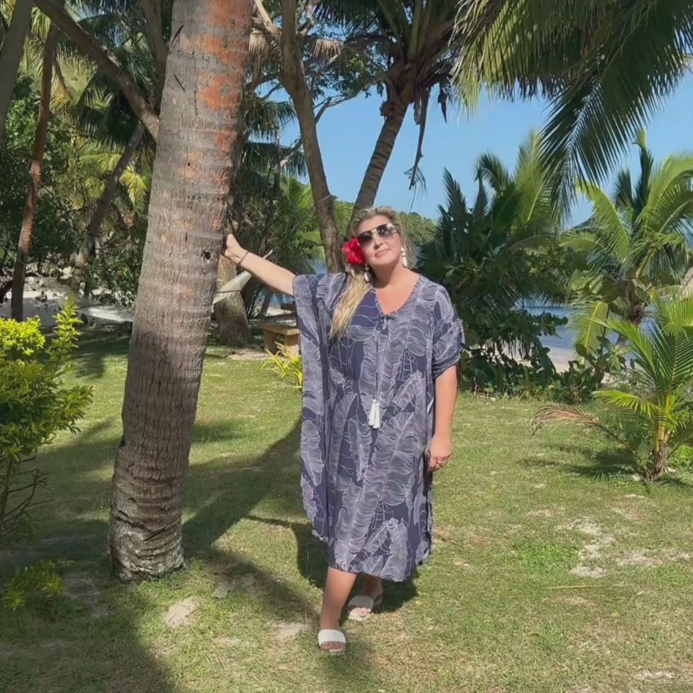 Under the beachside palm trees enjoying the comfort of the Blue Leaf Long Kaftan