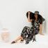 model wearing long kaftan dress with matching belt whilst sitting poolside in sun hat and black leather slides