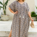 Woman wearing a leopard print maxi kaftan dress outdoors with plants in the background