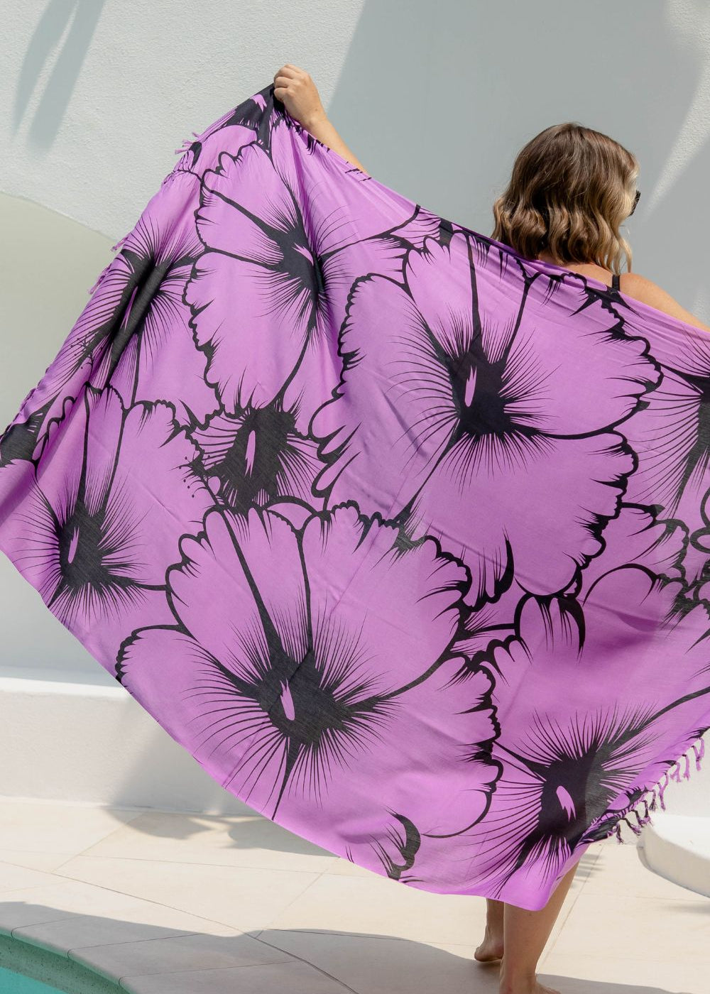 Person holding a large purple Hawaiian sarong with black floral print