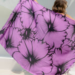 Person holding a large purple Hawaiian sarong with black floral print