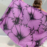Person holding a large purple Hawaiian sarong with black floral print