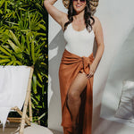 Alisha wearing L sarong in Mocha Mousse, front-on with sun hat, enjoying a sunny poolside moment in summer style