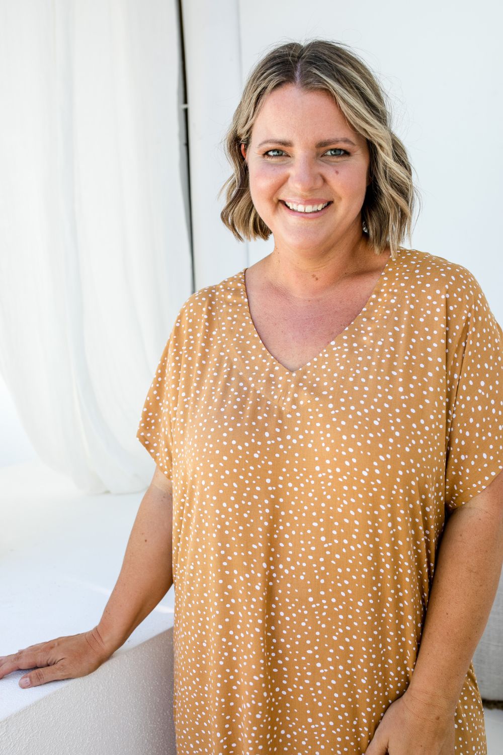 Close-up of Amanda wearing ML Caramel Scatter dress, showing detailed scatter print and soft V-neckline