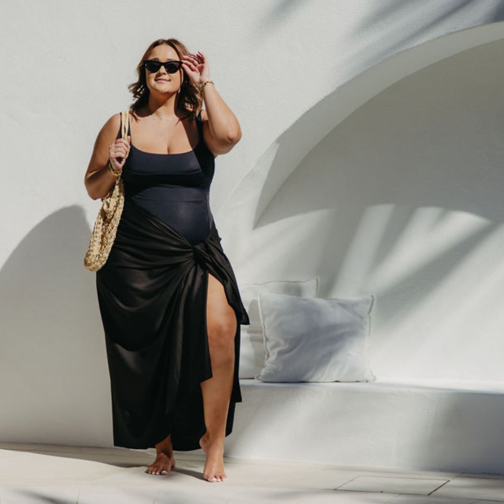 Woman wearing a black sarong over swimwear at the poolside resort