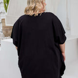 Close-up back view of a black kaftan top on a plus size model, showing fabric drape in size 2XL