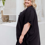 Side view of a black kaftan top on a plus size model, cropped to show fit and drape in size 2XL