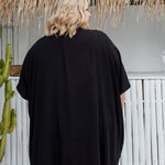 Back view of black kimono cape showing below-hip length on plus size woman