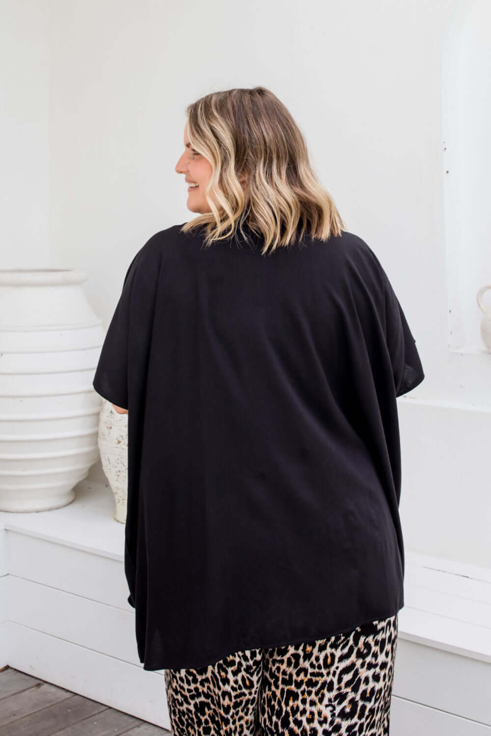 Back view of black kimono cape showing below-hip length
