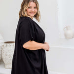 Side view of black kimono cape showing below-hip length