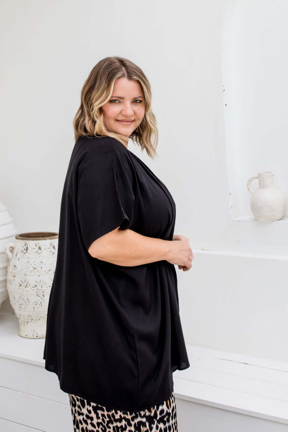 Side view of black kimono cape showing below-hip length