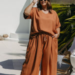 “Kate wearing Mocha Mousse Blouse Co-Ord Set size XL – front view by the pool with blouse front-tucked into matching wide-leg pants, styled with platform wedges and sunglasses