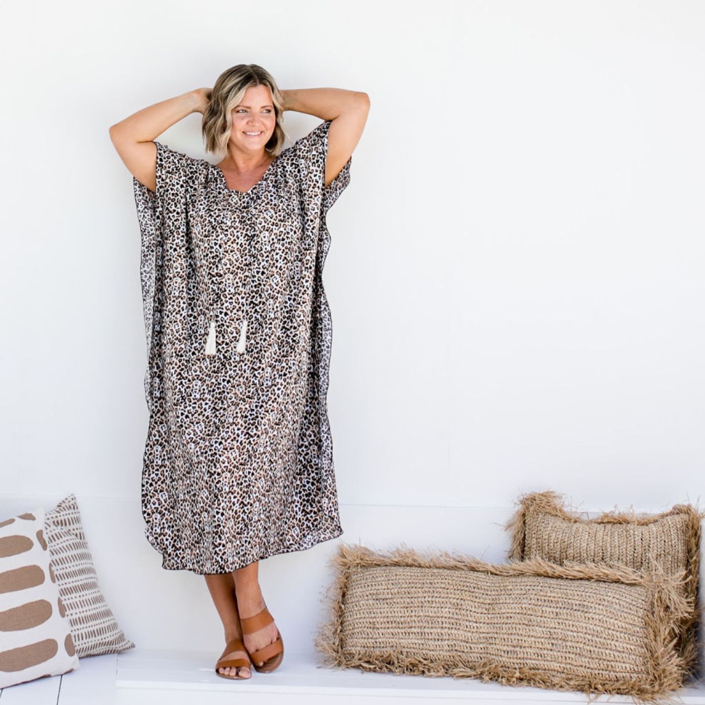 Model wearing Long kaftan dress in Earth Leopard print in warm neutral tones in poolside resort setting
