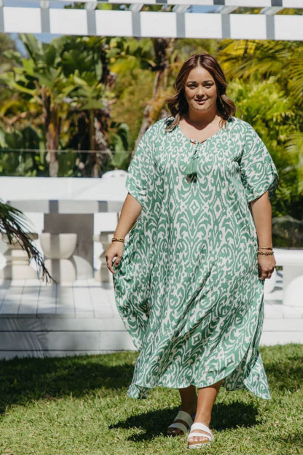 Woman walking outdoors in emerald green Sorrento print kaftan – resort wear