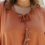 Close-up of Mocha Mousse Kaftan Top fabric on Kate showing rust-brown colour tone