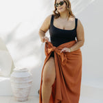 Kate wearing XL fringeless sarong in Mocha Mousse, front view showing ample fabric for a secure tie, poolside on a sunny day