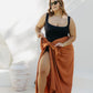 Kate wearing XL fringeless sarong in Mocha Mousse, front view showing ample fabric for a secure tie, poolside on a sunny day