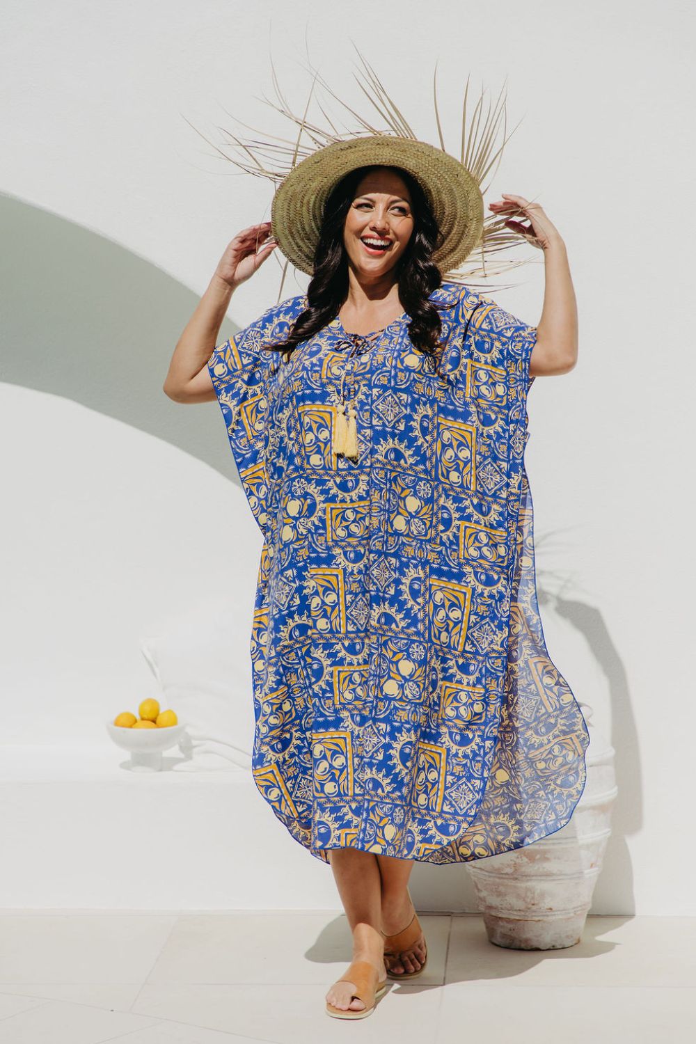 Woman wearing Long Summer kaftan dress called Limoncello poolside in seaside resort