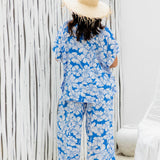 lady wearing a blue floral kaftan top with matching Palazzo pants at poolside resort