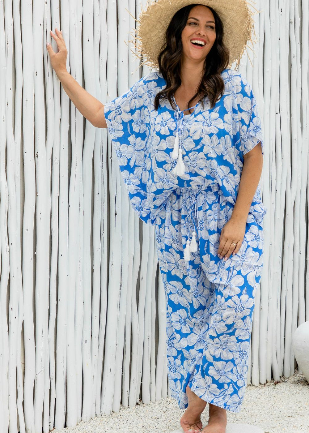 Woman wearing a blue floral relaxed fit pants and matching kaftan top on summer day