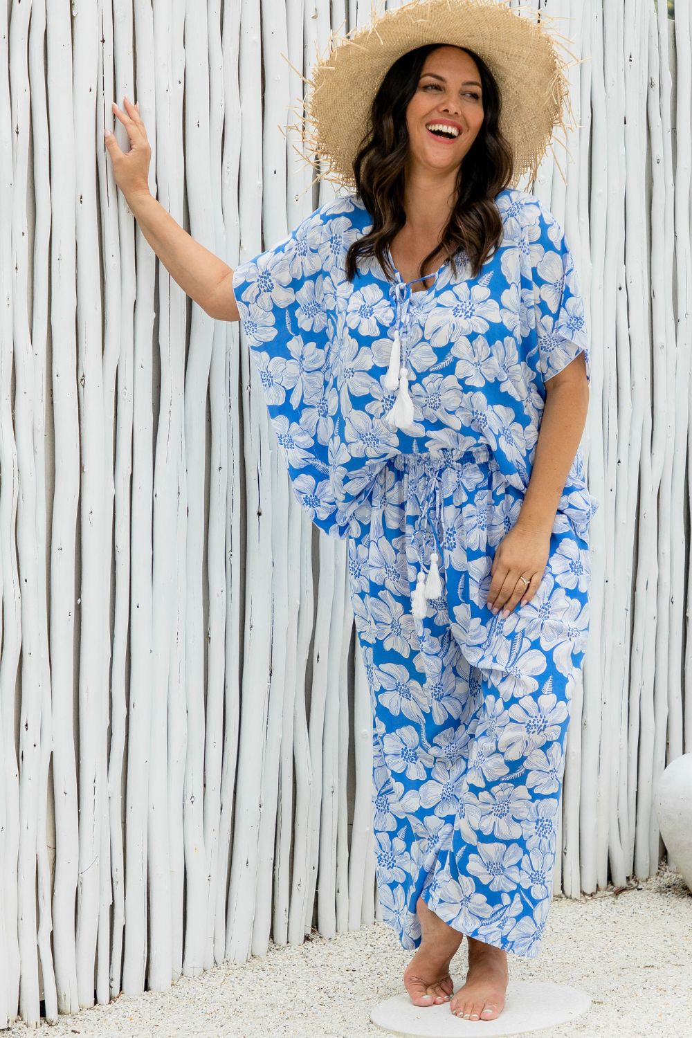 Woman wearing a blue floral relaxed fit pants and matching kaftan top on summer day