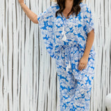 Woman wearing a blue floral relaxed fit pants and matching kaftan top on summer day