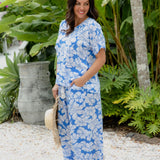 Woman in matching blue floral  Palazzo Pants and Summer Top standing in a resort garden