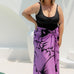 Woman wearing a purple floral sarong poolside for summer