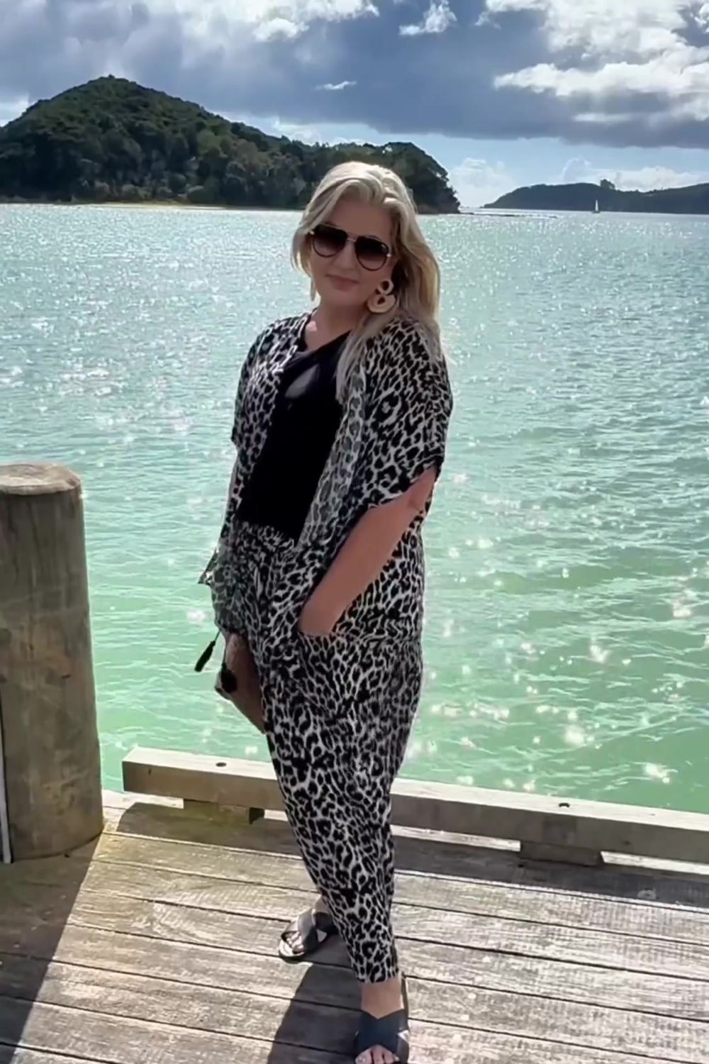 Woman wearing a leopard print kimono, black blouse and leopard print palazzo pants outfit set