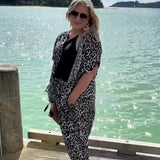 Woman wearing a leopard print kimono, black blouse and leopard print palazzo pants outfit set