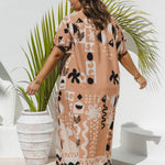 A plus size model wearing a long kaftan dress with black and white geometric patterns on soft terracotta, photographed from behind in a bright, modern outdoor setting with a potted palm plant.
