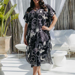 Woman wearing black and cream long kaftan in outdoor patio area