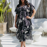 Woman wearing black and cream long kaftan in outdoor patio area