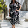 Woman wearing black and cream long kaftan in outdoor patio area