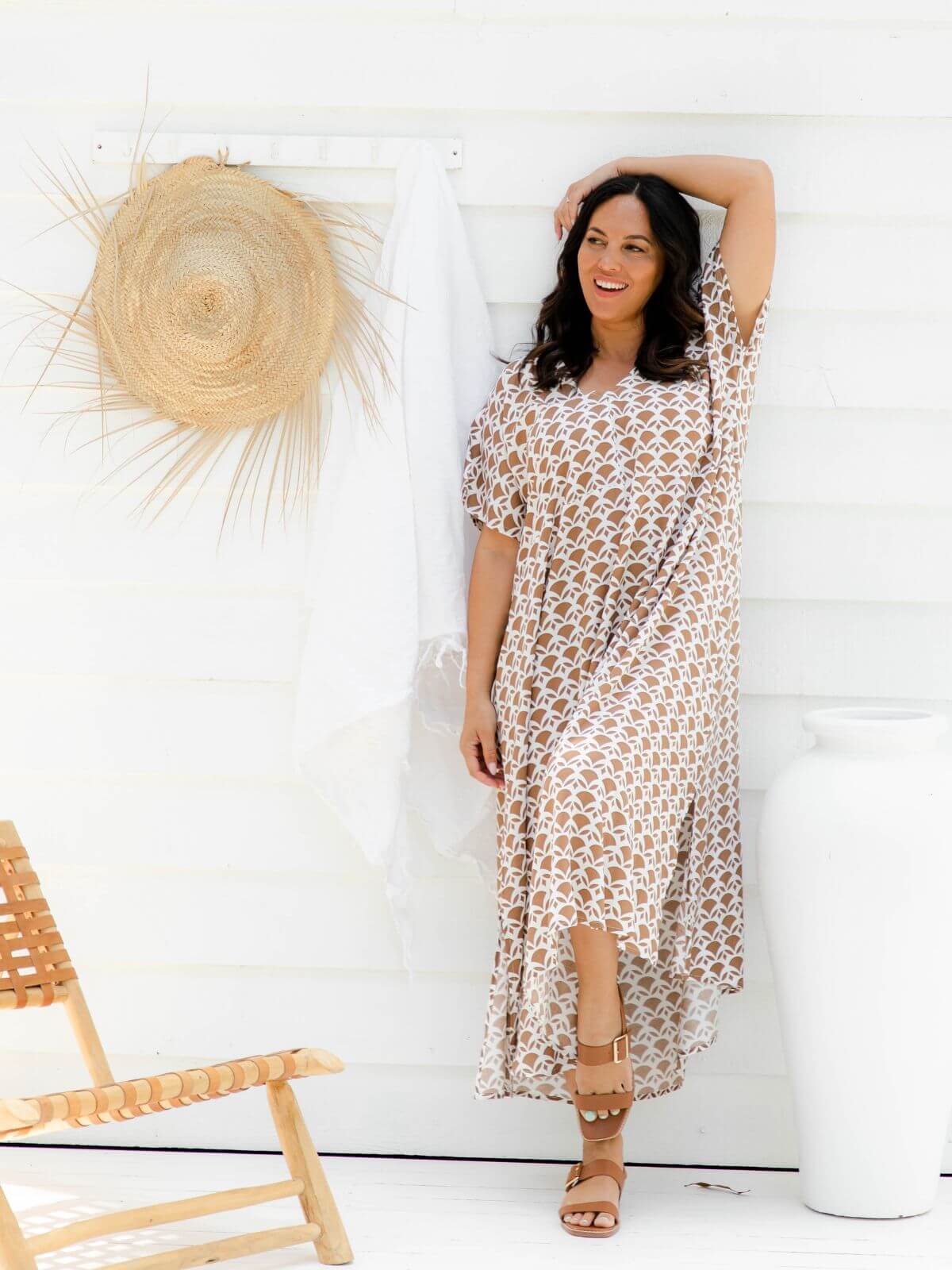 Mature model wearing mocha and white geometric empire line resort dress on outdoor deck