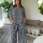 woman in Bali villa wearing outfit set of palazzo pants and top in black and white geometric print