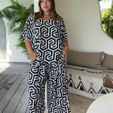 woman in Bali villa wearing outfit set of palazzo pants and top in black and white geometric print