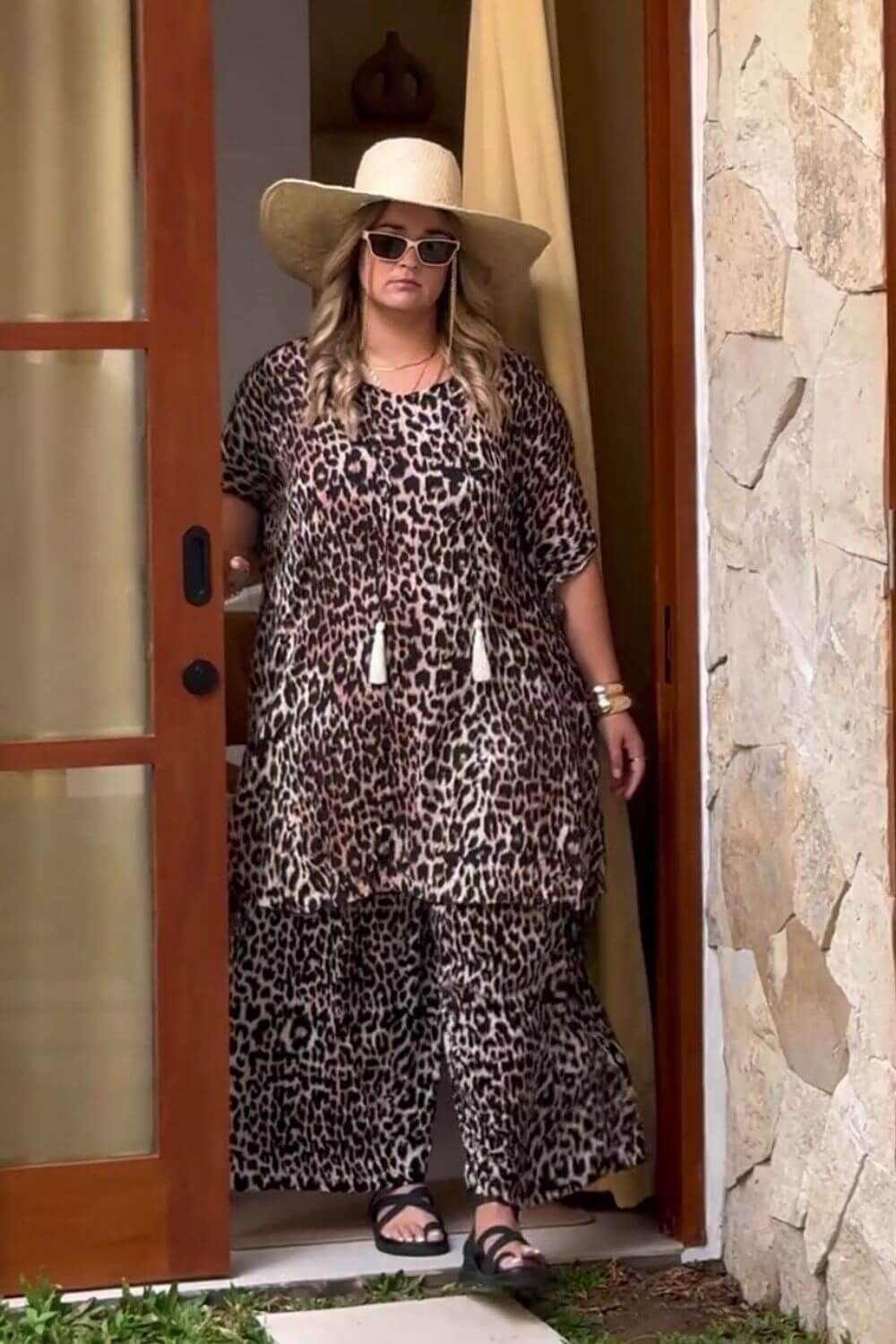 plus size woman walking out of Bali villa wearing outfit set of wide leg pants and short kaftan dress as co-ordinated look