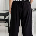 Half-length back view of black Palazzo Pants – relaxed wide-leg fit with soft drape