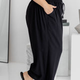 Side view of black Palazzo Pants with knee bent – showing wide-leg cut and functional pocket