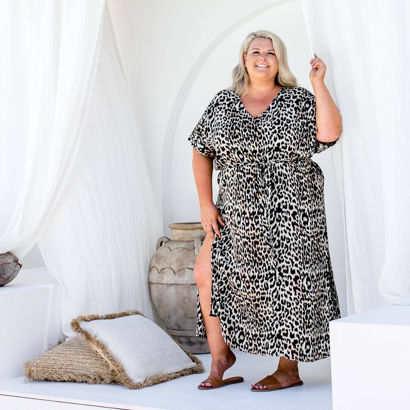Plus size model wearing a leopard print long kaftan dress outdoors