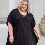 Close-up of a black kaftan top on a size 2XL model, showing relaxed fit and soft drape