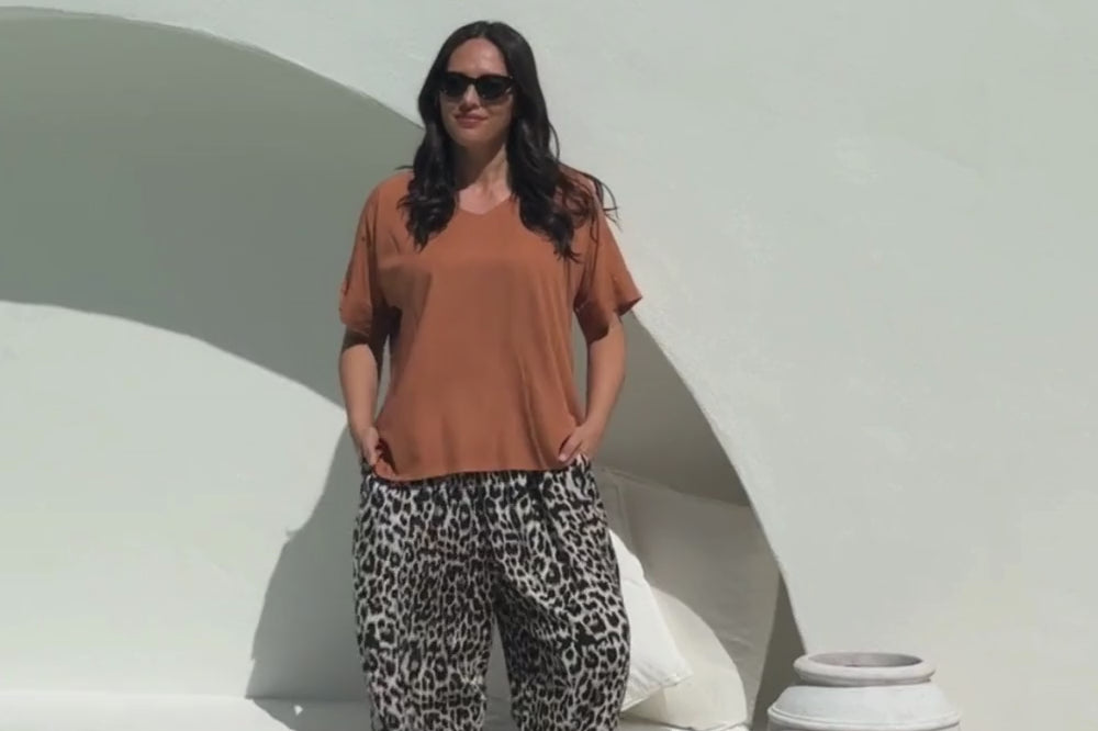 lady wearing a relaxed fit brown summer top and leopard print Palazzo pants 