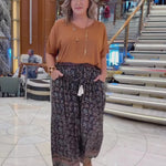 Woman on a cruise wearing floral relaxed fit Palazzo Pants paired with mocha mousse blouse top