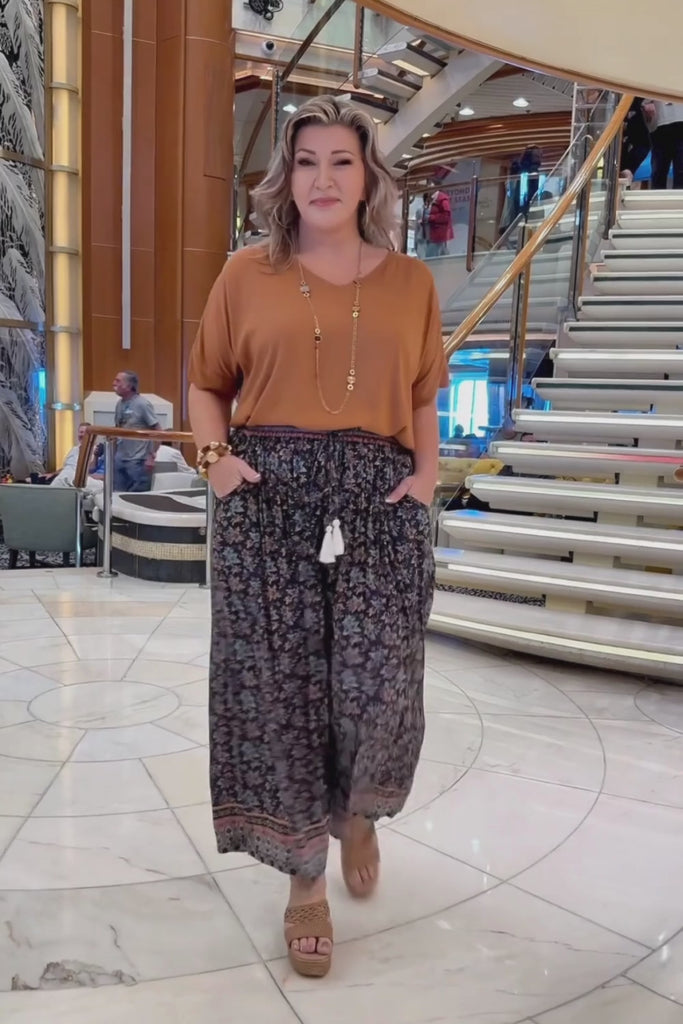 Woman on a cruise wearing floral relaxed fit Palazzo Pants paired with mocha mousse blouse top