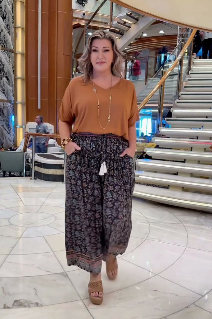 Woman on a cruise wearing floral relaxed fit Palazzo Pants paired with mocha mousse blouse top