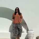 lady wearing a relaxed fit brown summer top and leopard print Palazzo pants 